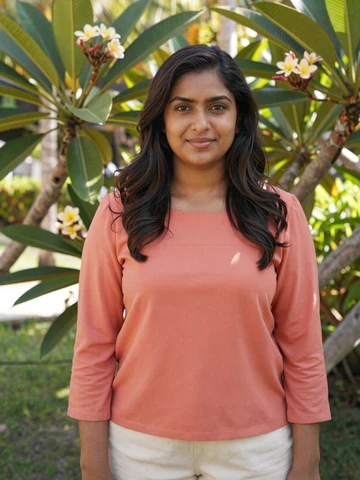 Smiling Maldivian woman in modest coral blouse in a tropical garden - Maldivian women dating profile